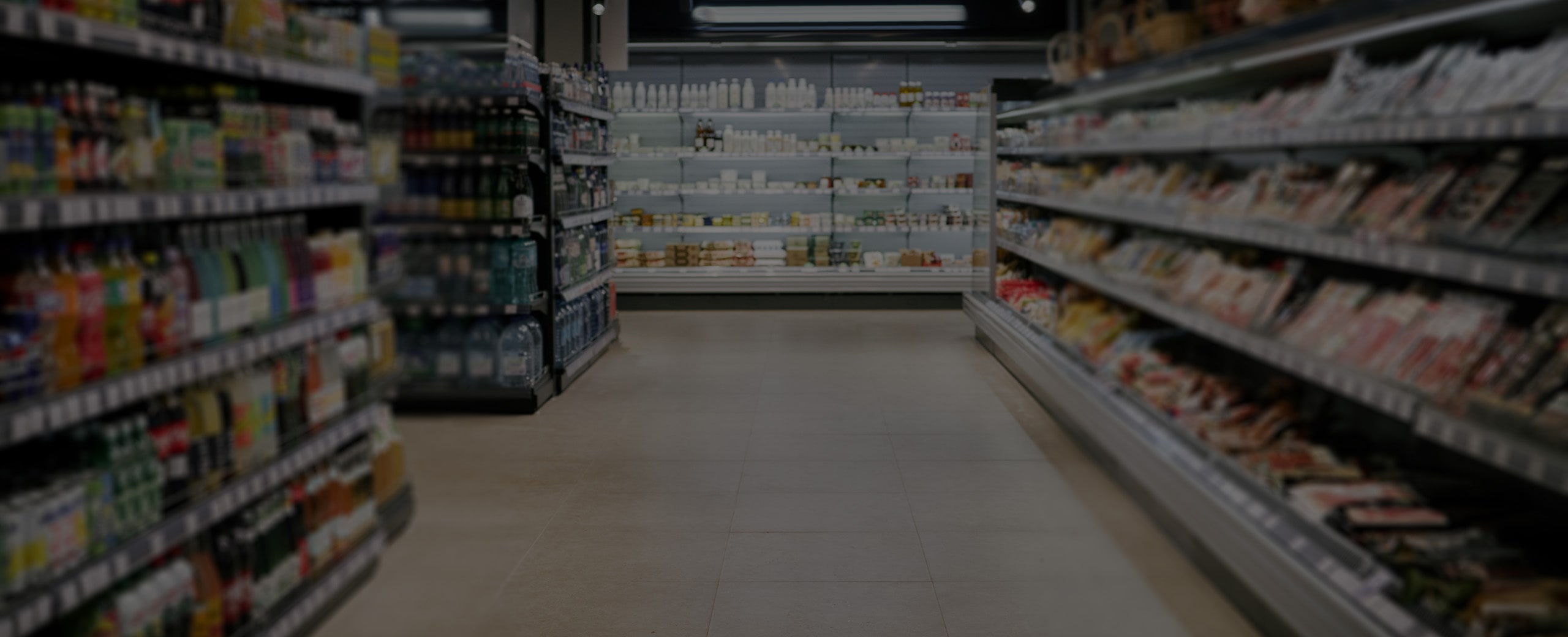 Empty supermarket aisle with stocked shelves, creating a calm, organized feel.